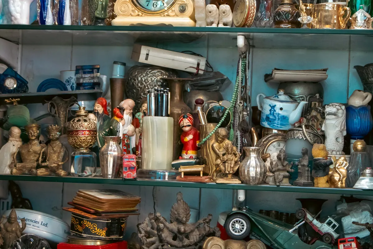 Regal voller Figuren, Teekanne, Spielzeugautos und Messing
