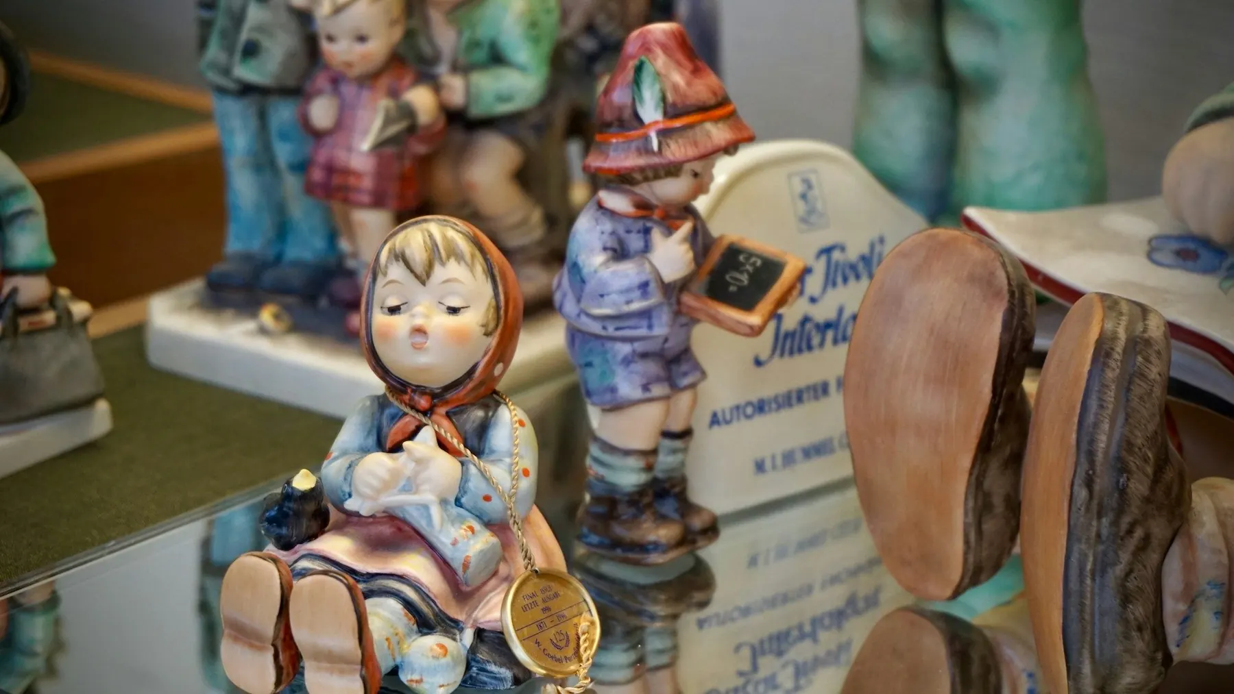 Porzellanfiguren von Kindern auf spiegelnder Fläche
