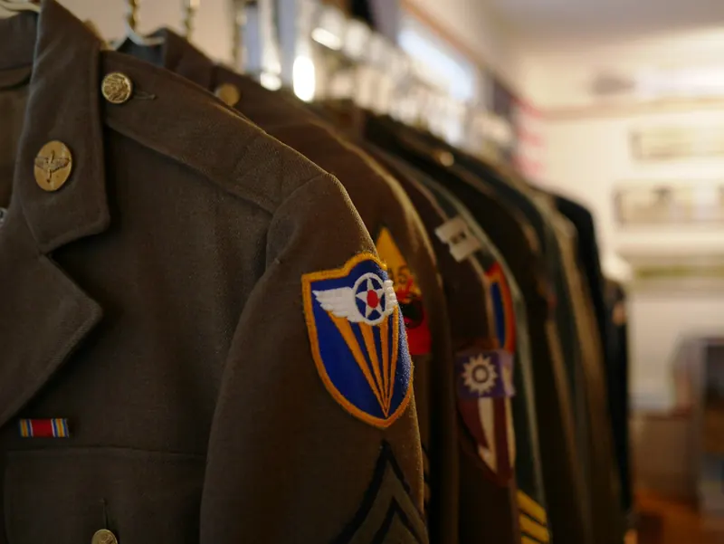 Olivgrüne Uniformjacken auf einer Kleiderstange